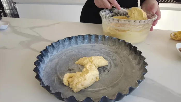 Stendere la frolla sulla teglia, formando la base e i bordi della crostata.