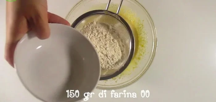 Setacciare 150g di farina 00 e 8g di lievito per dolci e mescolare con una frusta a mano.
