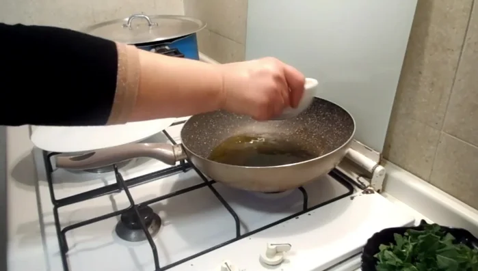 In una padella, soffriggere la rucola tagliata grossolanamente con l'olio d'oliva.
