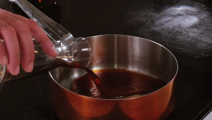 Preparare la salsa: in un pentolino, unire salsa di soia, mirin, una punta di aceto di riso e alga wakame. Portare a bollore e spegnere.