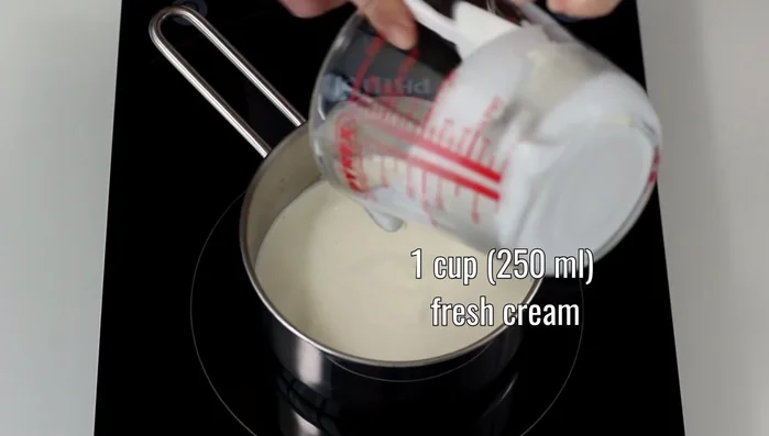 Per la salsa al caramello: versiamo 250ml di panna fresca in un pentolino e portiamo a ebollizione a fiamma media. Mettiamo da parte, coprendo.