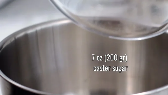 In un altro pentolino, versiamo 50ml di acqua e 200g di zucchero semolato. Riscaldiamo e cuociamo lo zucchero a fiamma media fino a caramellare (colore bruno). Spegniamo la fiamma.