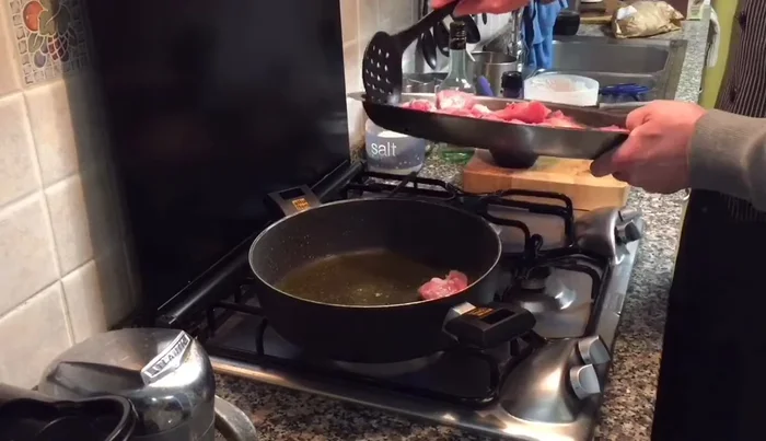 Rosolare il coniglio in olio extravergine di oliva, sigillando la carne per mantenere i succhi all'interno.