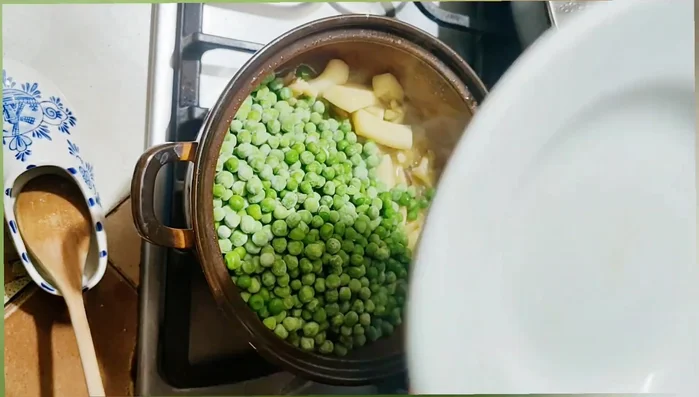 Quando le seppie sono tenere (si bucano facilmente con una forchetta), aggiungere i piselli. Coprire e continuare la cottura fino a quando anche i piselli sono teneri. Aggiungere acqua bollente se necessario.