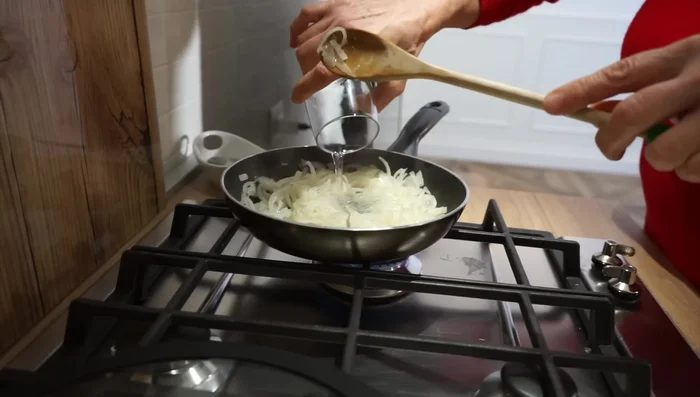 Dopo 3-4 minuti, aggiungete un po' d'acqua e lasciate stufare le cipolle con coperchio a fiamma bassa per altri 7-8 minuti, fino a quando saranno ben cotte.
