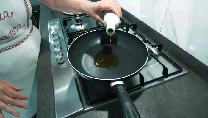In una padella, scaldare l'olio con uno spicchio d'aglio schiacciato. Una volta imbiondito, rimuovere l'aglio.