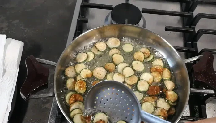 Scolare le zucchine su carta assorbente per eliminare l'olio in eccesso.