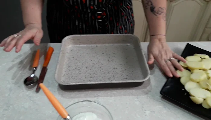 Ungere uno stampo da forno con il burro. Disporre uno strato di fette di patate sul fondo dello stampo.