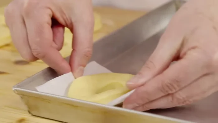 Disporre le ciambelle su carta forno e lasciar lievitare per altri 20 minuti.