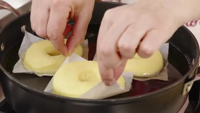 Friggere le ciambelle in abbondante olio caldo fino a doratura, girandole un paio di volte. Rimuovere con una pinza e scolare su carta assorbente.