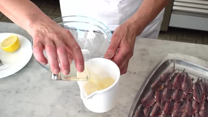 Preparare la marinatura: in una ciotola, mescolare aceto di vino bianco, vino bianco secco, succo di limone e sale grosso.