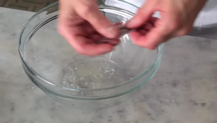 Sistemare le alici in un contenitore, creando strati e alternandoli con la marinatura.