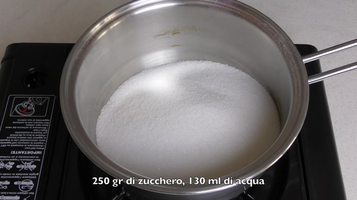 Metti in una casseruola 250 g di zucchero e 130 ml di acqua. Fai sciogliere completamente a fiamma bassa, mescolando continuamente.