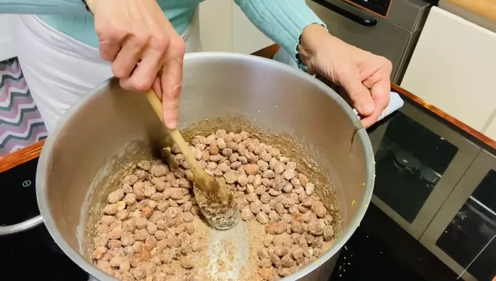 Le mandorle inizieranno a caramellare, diventando scure. Continuare a mescolare fino a quando tutte le mandorle saranno ricoperte di caramello scuro.