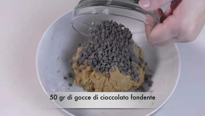 Unire 50 g di gocce di cioccolato fondente e lavorare brevemente con le mani per incorporarle.
