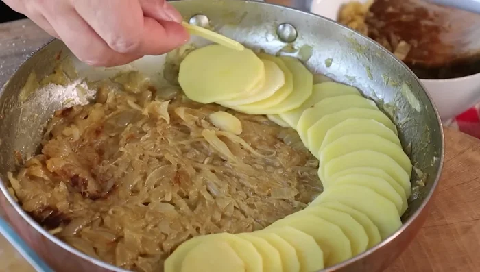 Assemblare il pasticcio: preriscaldare il forno a 180° (266.639). In una padella o pentola, disporre uno strato di patate accavallate, poi metà delle cipolle rosolate, burro, sale, pepe, erbe aromatiche e formaggio grattugiato (269.44). Ripetere gli strati per un totale di tre, terminando con uno strato di patate (330.4).