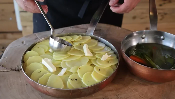 Aggiungere il brodo: versare il brodo vegetale fino a raggiungere il livello delle patate, circa 1 cm sotto il bordo (353.199).
