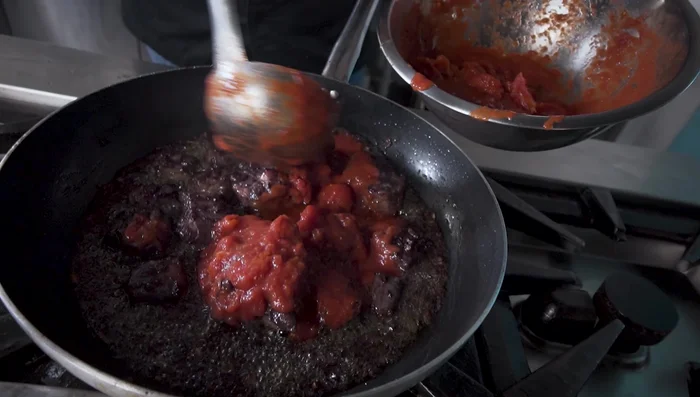 Una volta evaporato il vino, aggiungere i pomodori pelati.