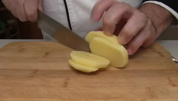 Pelare le patate e metterle in acqua per evitare l'ossidazione (124.0). Tagliarle a cubetti di dimensioni uniformi (136.519).