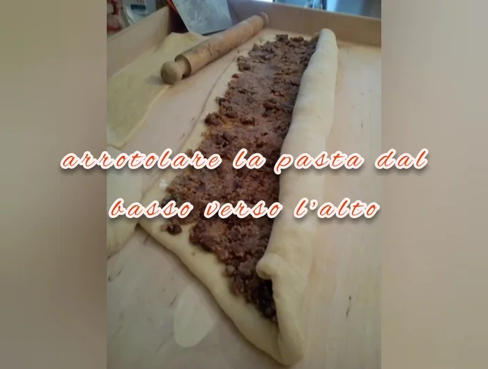 Arrotolare la pasta dal basso verso l'alto, formando una spirale.