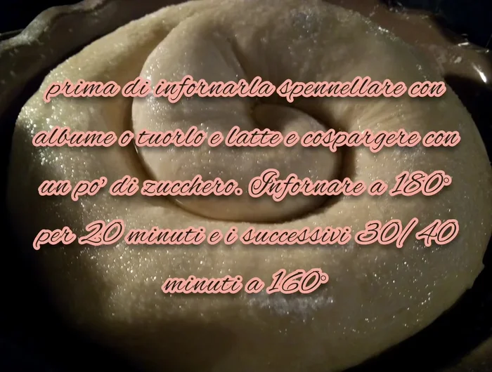 Spennellare la gubana con albume d'uovo e latte, cospargere di zucchero e infornare a 180°C per 20 minuti, poi a 160°C per altri 30-40 minuti.
