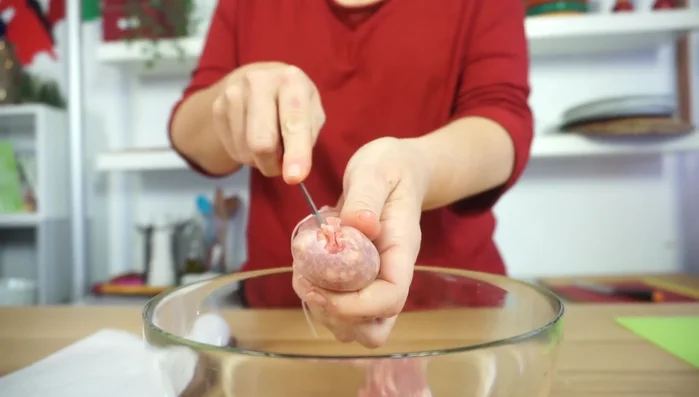 Preparate la farcitura: in una ciotola mettete la salsiccia privata del suo budello, castagne spezzettate, prugne tritate, scalogno tritato e spezie.