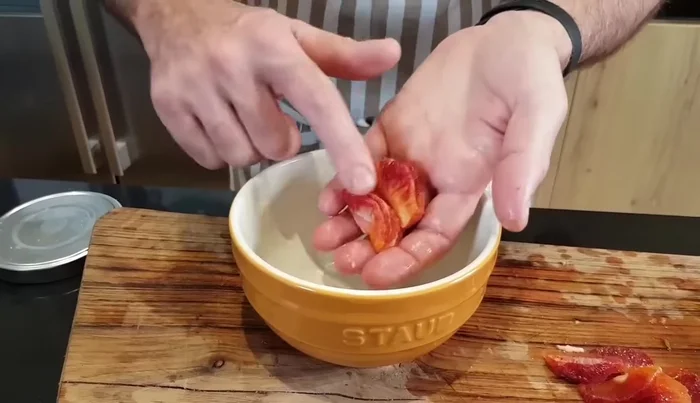 Spremere gli scarti delle arance per ottenere il succo.
