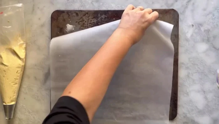 Rivestire una teglia con carta da forno, fissandola leggermente alla base. Formare i biscotti sulla teglia, cercando di farli tutti uguali. Abbassare le eventuali codine con un goccio d'acqua.