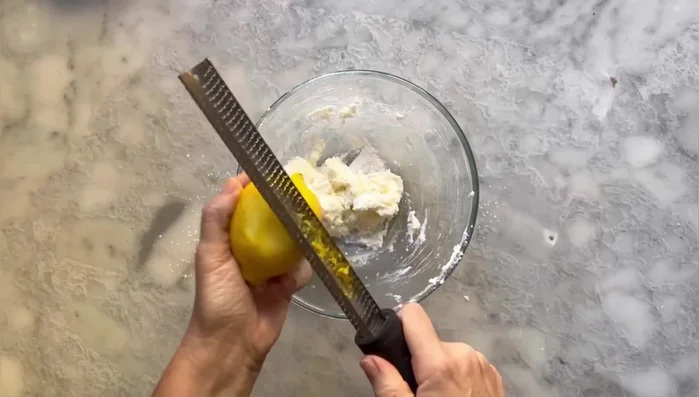 Aggiungere la scorza di limone e l'estratto di vaniglia. Montare bene il composto con la frusta elettrica.
