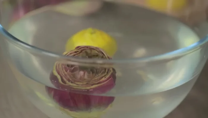 Immergere i carciofi puliti nell'acqua acidulata per mantenerli integri. Coprire i carciofi con carta assorbente.