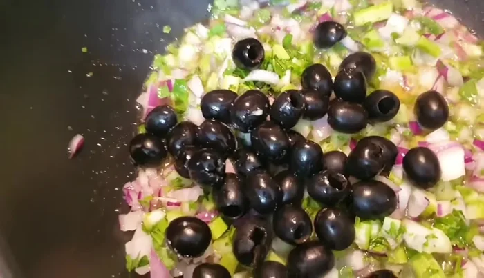 Aggiungere le olive (verdi sarebbero ideali), il concentrato di pomodoro e mezzo bicchiere d'acqua. Mescolare bene.