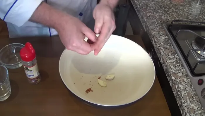 In una Wok, rosolare l'altro spicchio d'aglio (privato dell'anima) e il peperoncino con un filo d'olio extravergine di oliva.