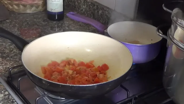 Filtrare il brodo di gamberi con un colino.