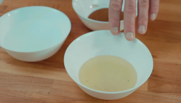Preparare la bagna: sciogliere 100g di zucchero in 70g di acqua con l'infuso di bacche di vaniglia. Scaldare acqua a 70°C, aggiungere il Nescafè e mescolare.