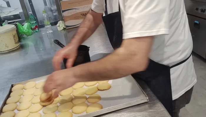 Sciogliere del cioccolato fondente e glassare metà dei biscotti. Decorare a piacere con mandorle a lamelle o zuccherini.