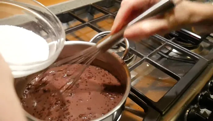 Aggiungere lo zucchero al latte caldo sul fuoco.