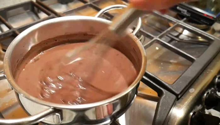 Versare il composto di cacao, zucchero e fecola nel latte caldo.