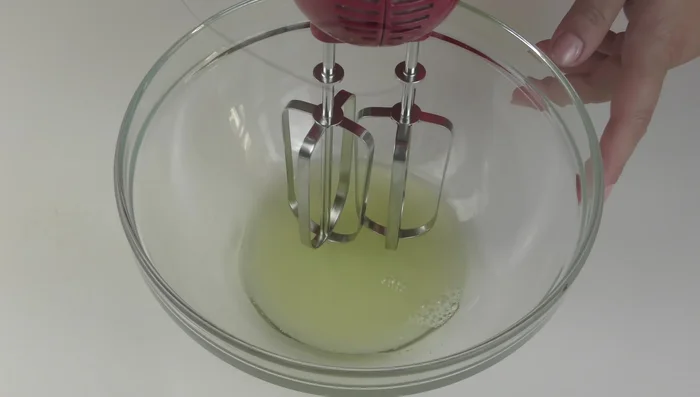 In una ciotola capiente, montare a neve ben ferma 60 g di albumi pastorizzati con una frusta elettrica.
