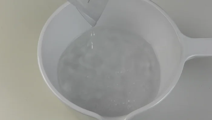 In una casseruola, unire 600 ml di acqua, 180 g di zucchero e le bucce di limone. Portare a bollore a fuoco dolce per circa 3 minuti.