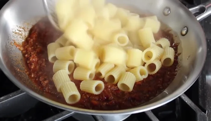 Cuocere la pasta al dente. Mescolare la pasta con il ragù prima di servire.