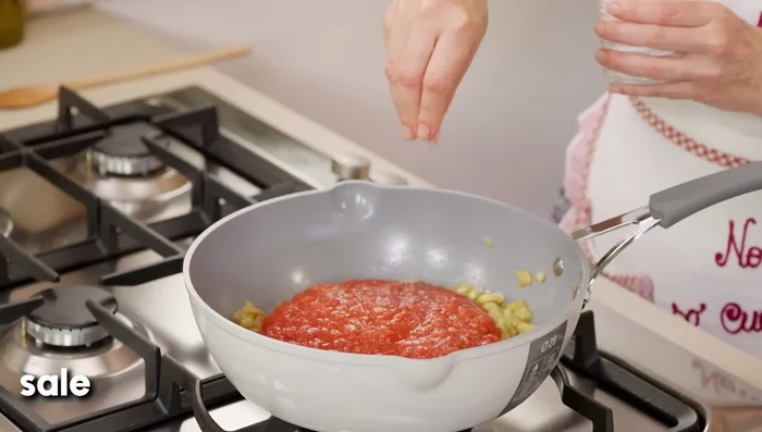 Aggiungere la passata di pomodoro, aggiustare di sale e cuocere per altri 10 minuti. Verso fine cottura, aggiungere il basilico.