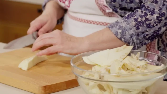 Nel frattempo, preparare il ripieno: scaldare un po' d'olio in una padella, aggiungere uno spicchio d'aglio e la polpa di melanzana a pezzettini. Cuocere per una decina di minuti.