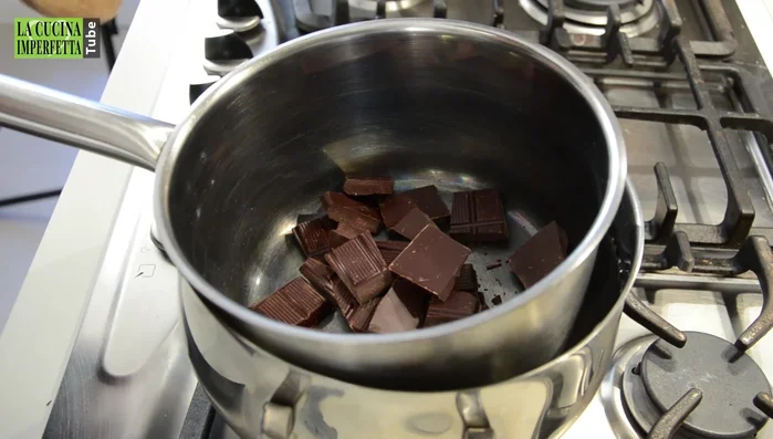 Sciogliere il cioccolato a bagnomaria a fuoco basso, unendo il burro una volta che il cioccolato inizia a fondere. Mescolare fino a completo scioglimento.