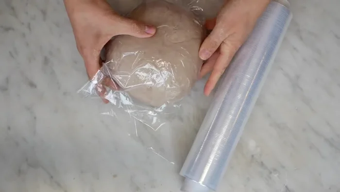 Far riposare l'impasto: Avvolgere il panetto nella pellicola e lasciarlo riposare in frigorifero per almeno 30 minuti (o fino a 3-4 giorni). [88.77]