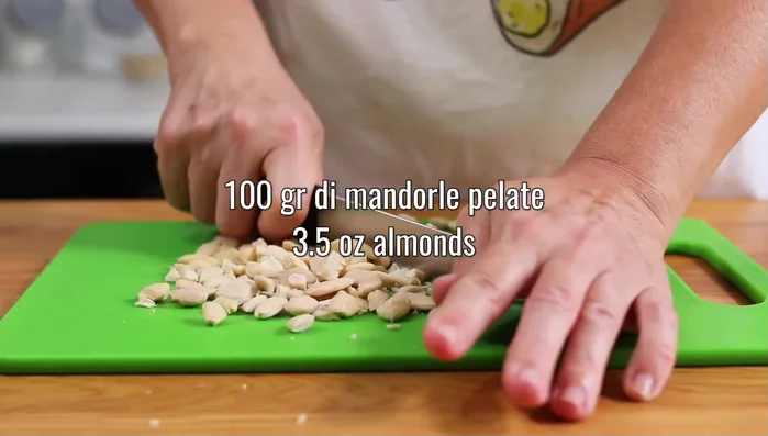 Sminuzzare 100 g di mandorle pelate.