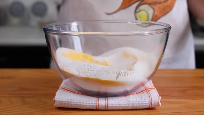Aggiungere 200 g di zucchero semolato, le mandorle sminuzzate, la scorza grattugiata di mezzo limone bio, 40 g di tuorli, 140 g di burro ammorbidito, 60 g di strutto, 70 g di mandorle intere e un pizzico di sale.