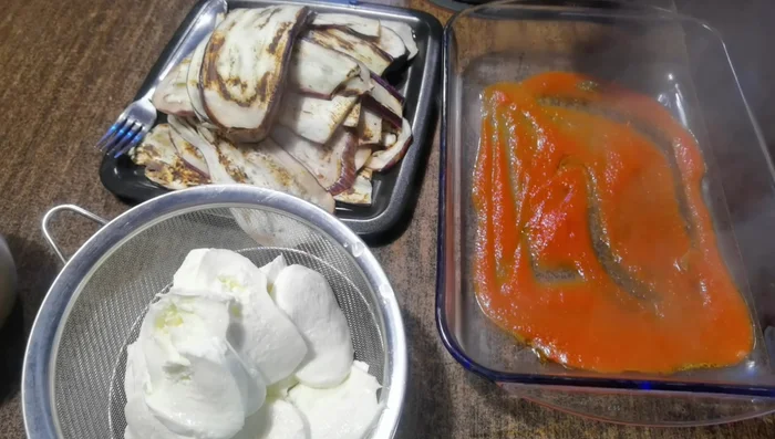 Creare strati nella pirofila: sugo, melanzane grigliate, mozzarella light, parmigiano.