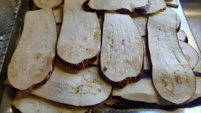 Affettare le melanzane a fette di circa 1 cm e metterle sotto sale per togliere l'acqua di vegetazione.