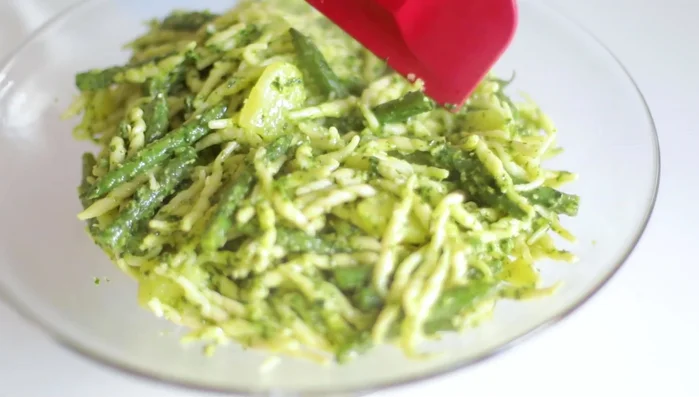 Servire le trofie al pesto, guarnendo con i pinoli rimanenti.