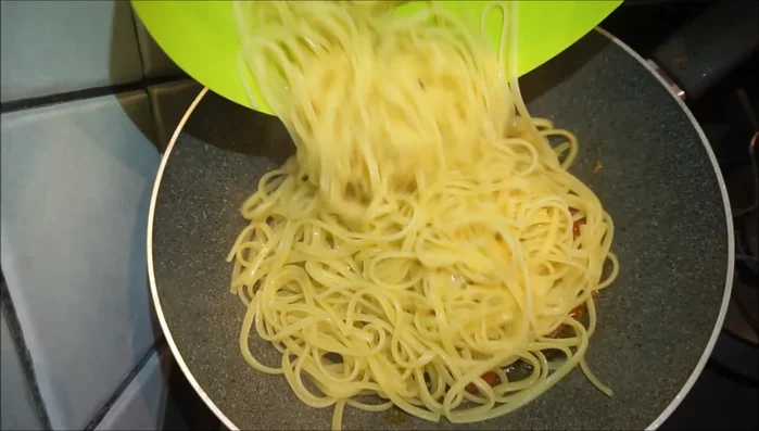Scolare le linguine e aggiungerle ai pomodorini in padella.